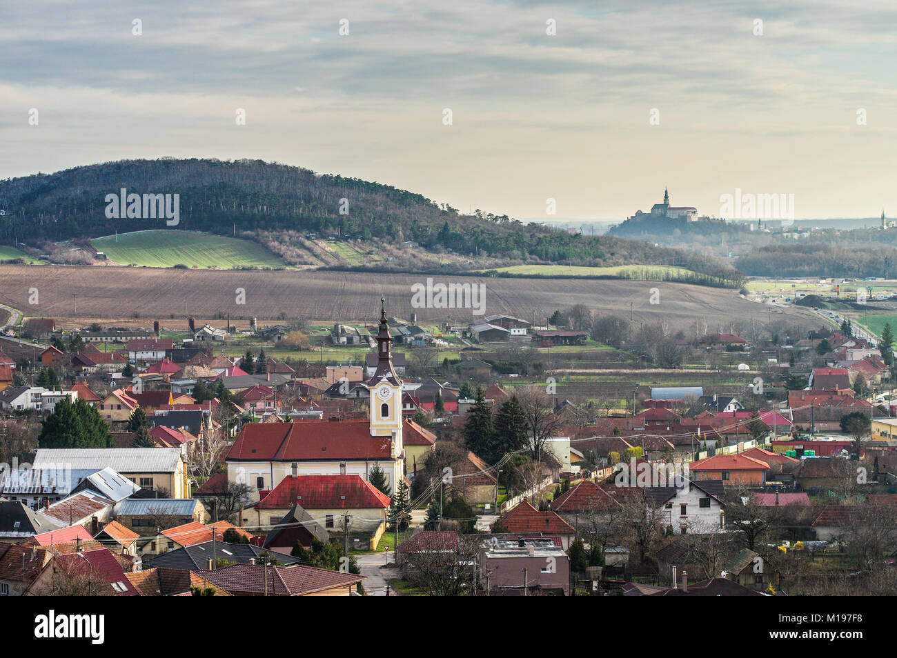 Village pittoresque de Drazovce avec la ville et le château de Nitra sur la colline en arrière-plan - Slovaquie Banque D'Images