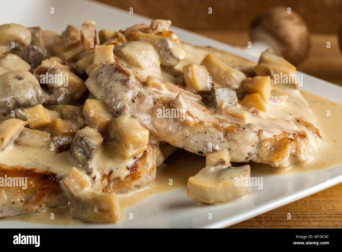 Surlonge de porc avec sauce blanche faite à partir de la crème et des champignons sur fond de bois Banque D'Images