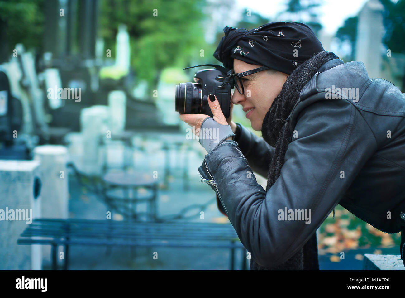 Hispanic Female photographer taking photos macro sur un cimetière Banque D'Images