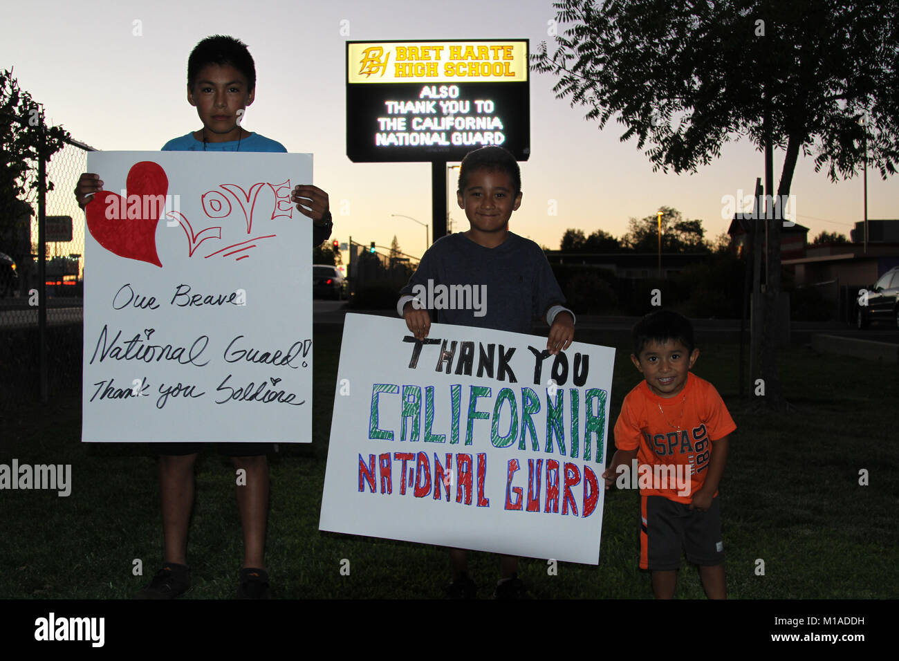 Les résidents de Angels Camp Juan Velazquez, 12 ans, Edgar Gonzales, 6 et Jésus Ortega, 3, montrent des signes d'appréciation fSept. 23 l'armée ou la garde nationale de Californie qui combattent l'incendie en comté de Butte, en Californie. Plus de 250 gardes de la Californie sont nettoyer des zones sensibles, de la récupération des tuyaux d'eau et l'assainissement de zones dans les 70 000 hectares de forêt, une des plus meurtrières de la Californie cette année. (U.S. Photo de la Garde nationale par le sergent. Eddie Sigüenza) Banque D'Images