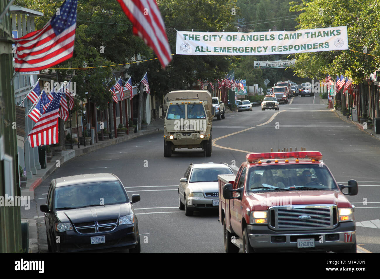 Dirigé par un California Division des forêts et la protection contre les incendies (CAL FIRE), un représentant de la Garde nationale de Californie véhicule tactique des troupes transporte le 24 septembre au San Andreas Hills dans le centre-ville d'Angels Camp, une ville de Californie dans le comté de qui a été dévastée par l'incendie de Butte. Les collectivités et les petites villes comme Angels Camp ont montré un soutien constant pour les gardes de la Californie et d'autres éléments de lutte contre les incendies avec des bannières et des signes montrant leur appréciation. (U.S. Photo de la Garde nationale par le sergent. Eddie Sigüenza) Banque D'Images
