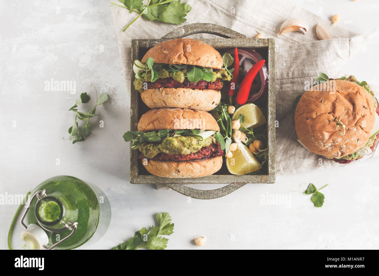 Betterave Vegan burgers de pois chiches aux légumes, guacamole et de seigle petits pains en boîte en bois. La nourriture végétalienne saine concept. Banque D'Images