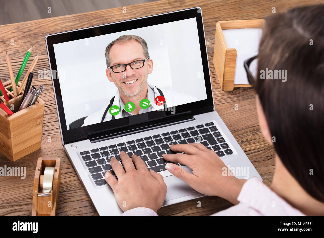 Close-up of a Woman le chat vidéo avec un médecin homme On Laptop Banque D'Images