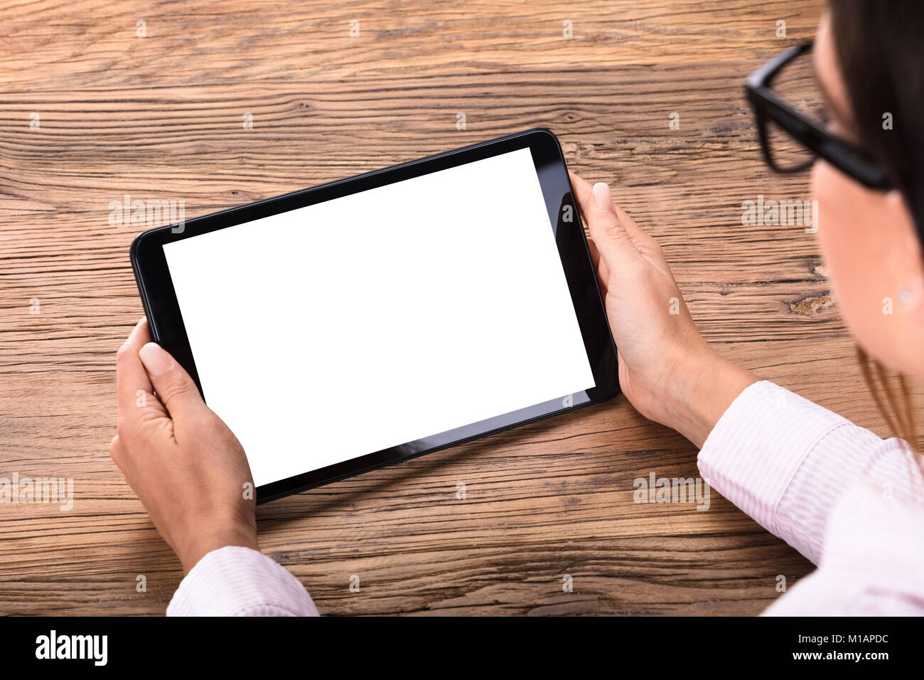 Close-up of a Businesswoman Holding Digital Tablet avec écran blanc dans la main sur un bureau en bois Banque D'Images