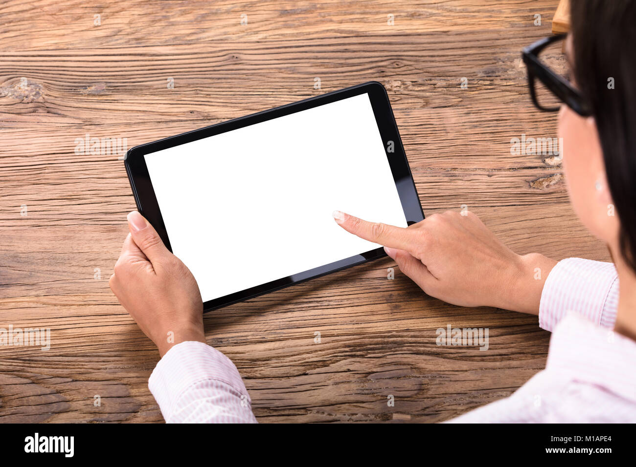 Close-up of a Businesswoman Holding Digital Tablet avec écran blanc dans la main sur un bureau en bois Banque D'Images