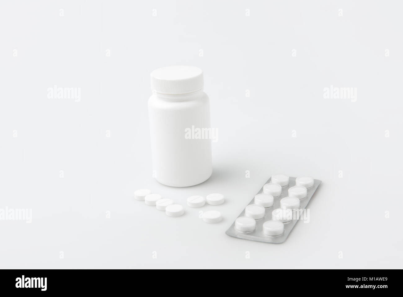 Conteneur, pilules et comprimés dispersés dans paquet isolé sur fond blanc Banque D'Images