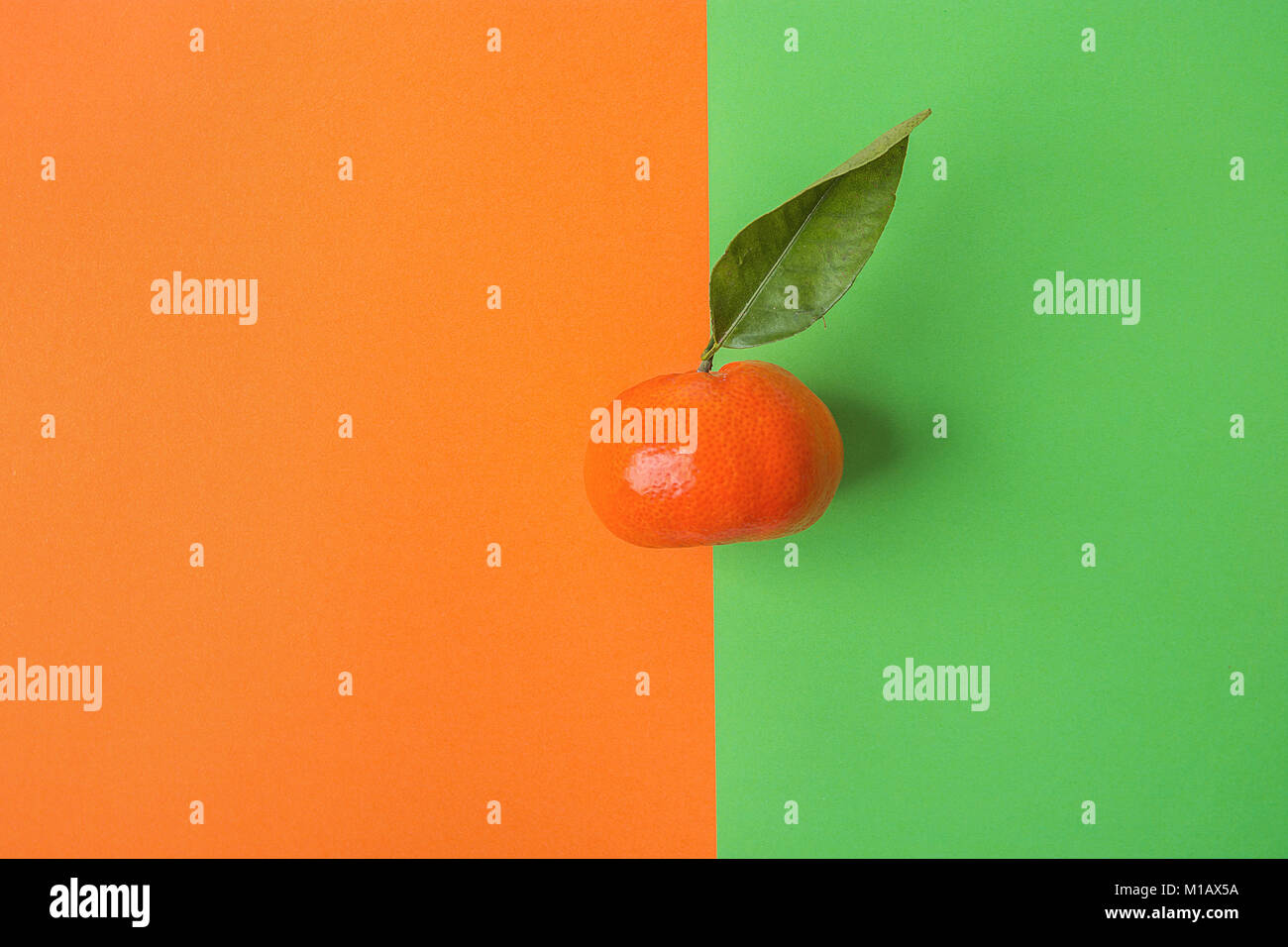 La mandarine mure lumineux unique sur fond de contraste à partir de la combinaison de couleurs Vert Orange. Titre image créative. Fruits tropicaux Vacances Été Bea Banque D'Images