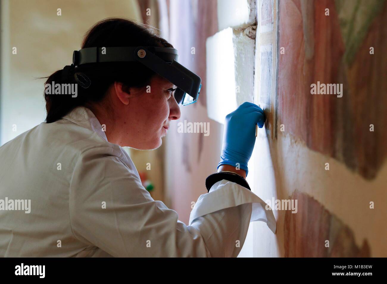 Un restaurateur à la fresque historique à une par une loupe. La restauration du patrimoine culturel - 'open' Restauration atelier à l'église o Banque D'Images