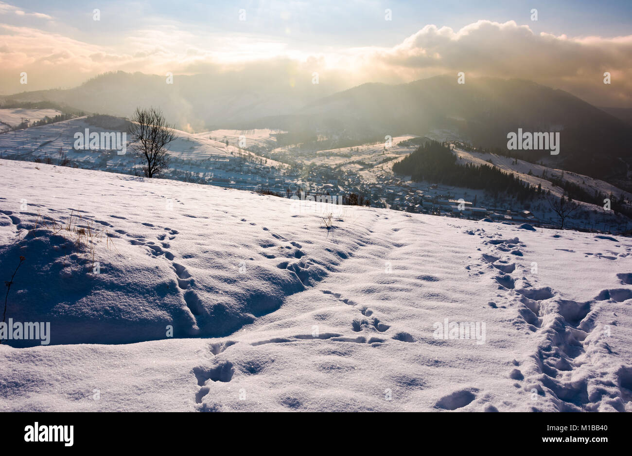 Pente enneigée en campagne montagneuse. superbe météo avec nuages sur la crête de montagne. Banque D'Images