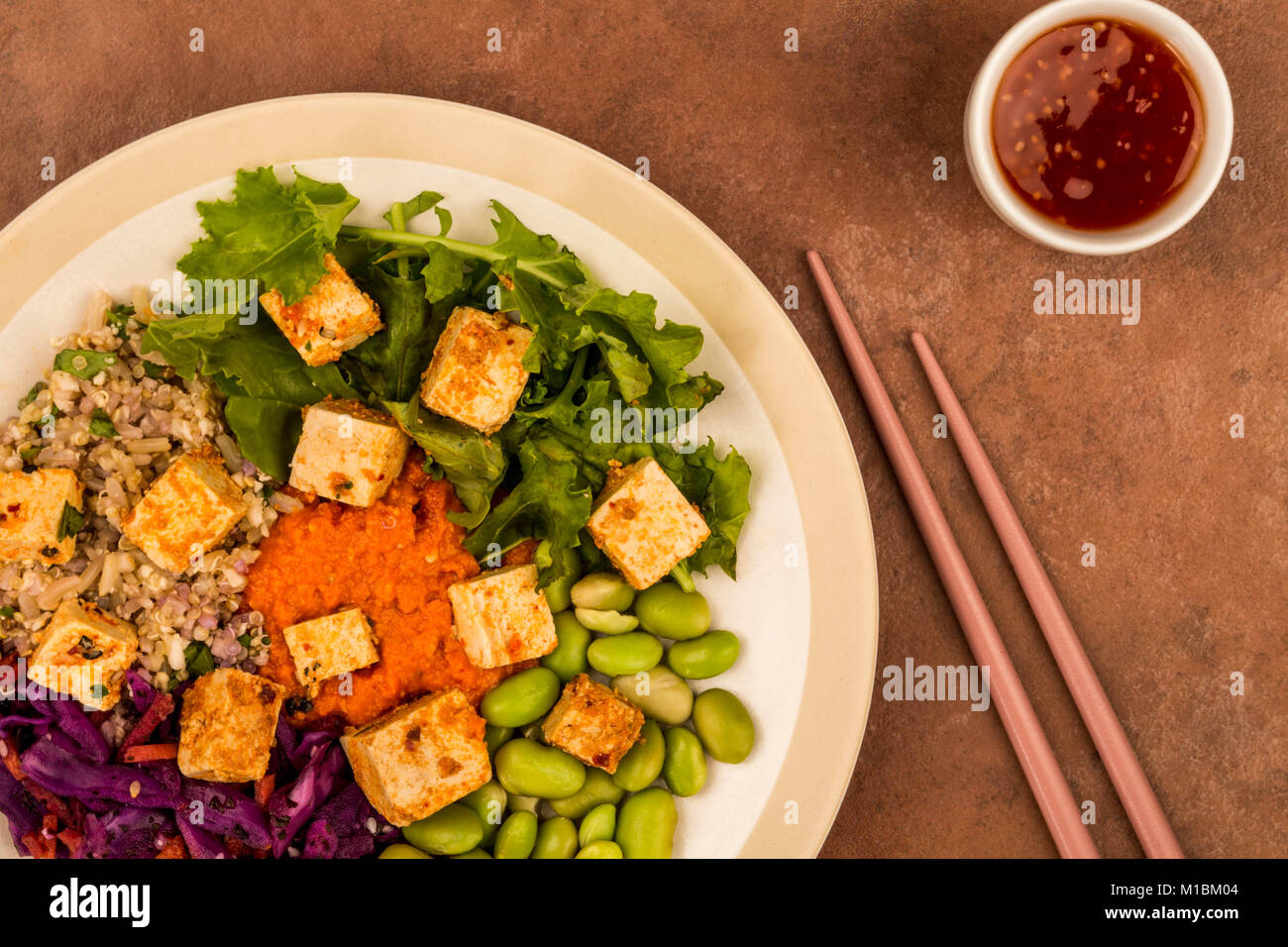 Style asiatique végétarien ou végétalien épicé Salade de tofu sur un fond rouge Banque D'Images