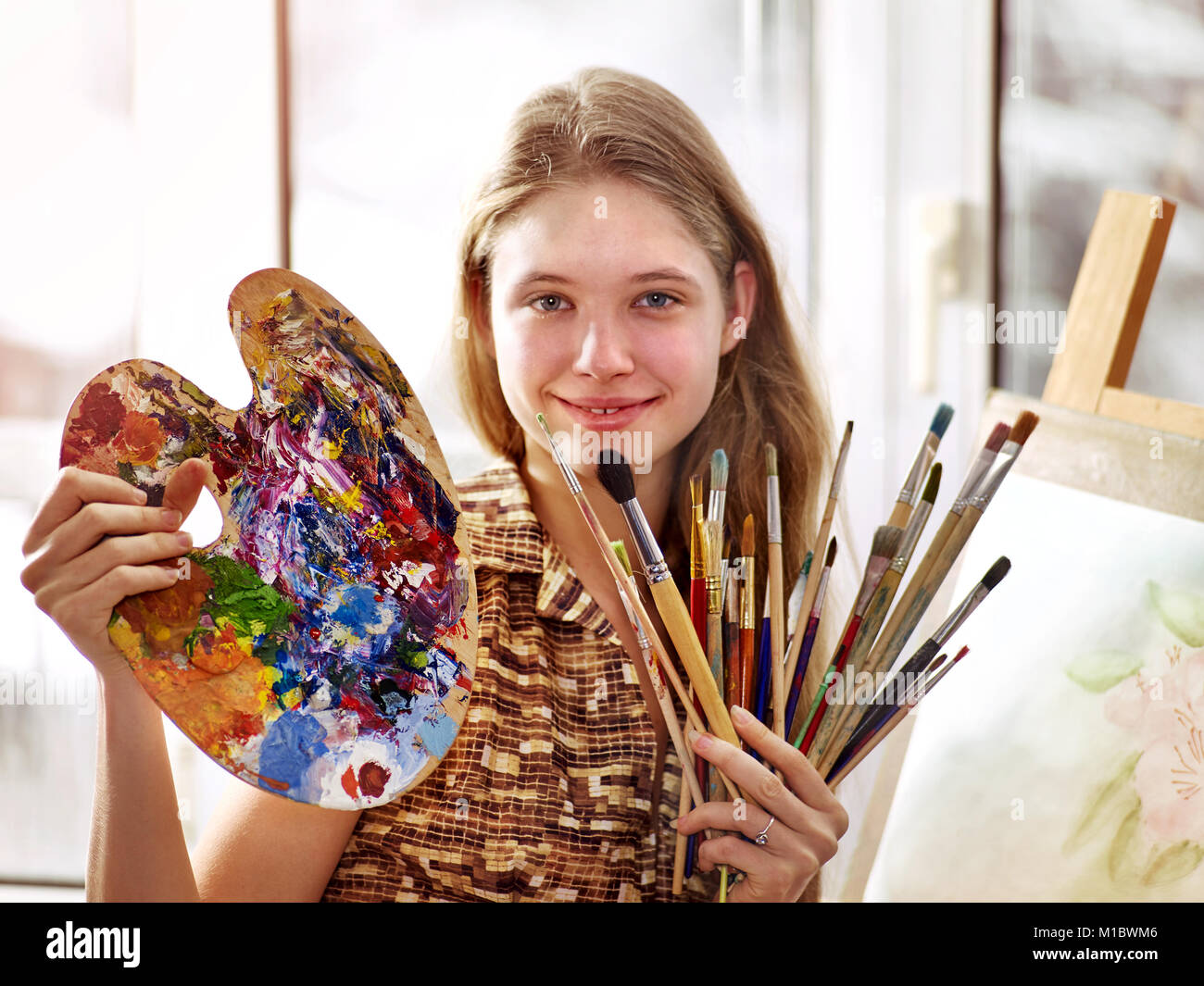 Artiste peinture sur chevalet dans Studio. Les peintures de fille avec un pinceau. Banque D'Images