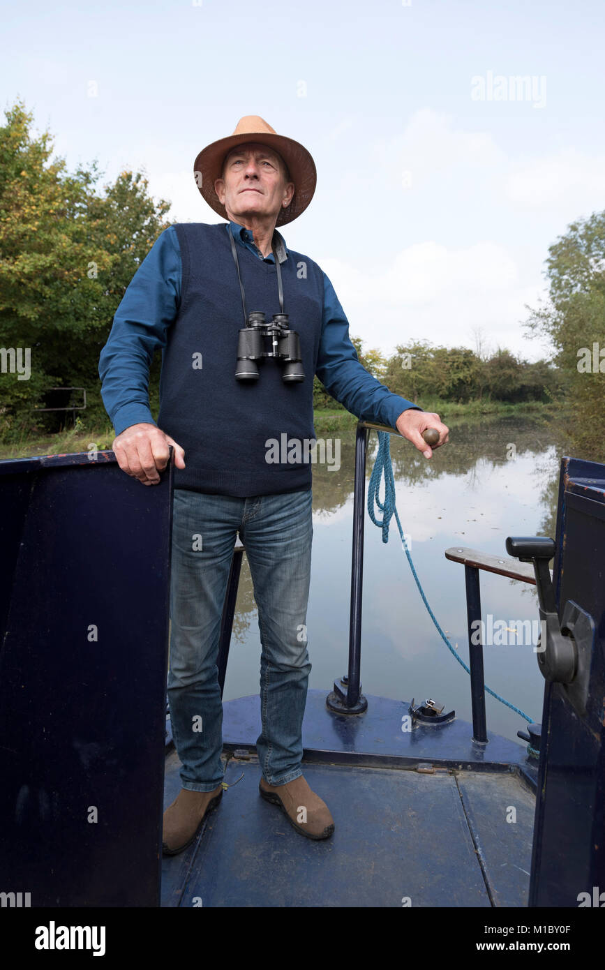 Capitaine d'un grand classique portant un chapeau de paille d'une direction intérieure le bateau avec le timon. Banque D'Images