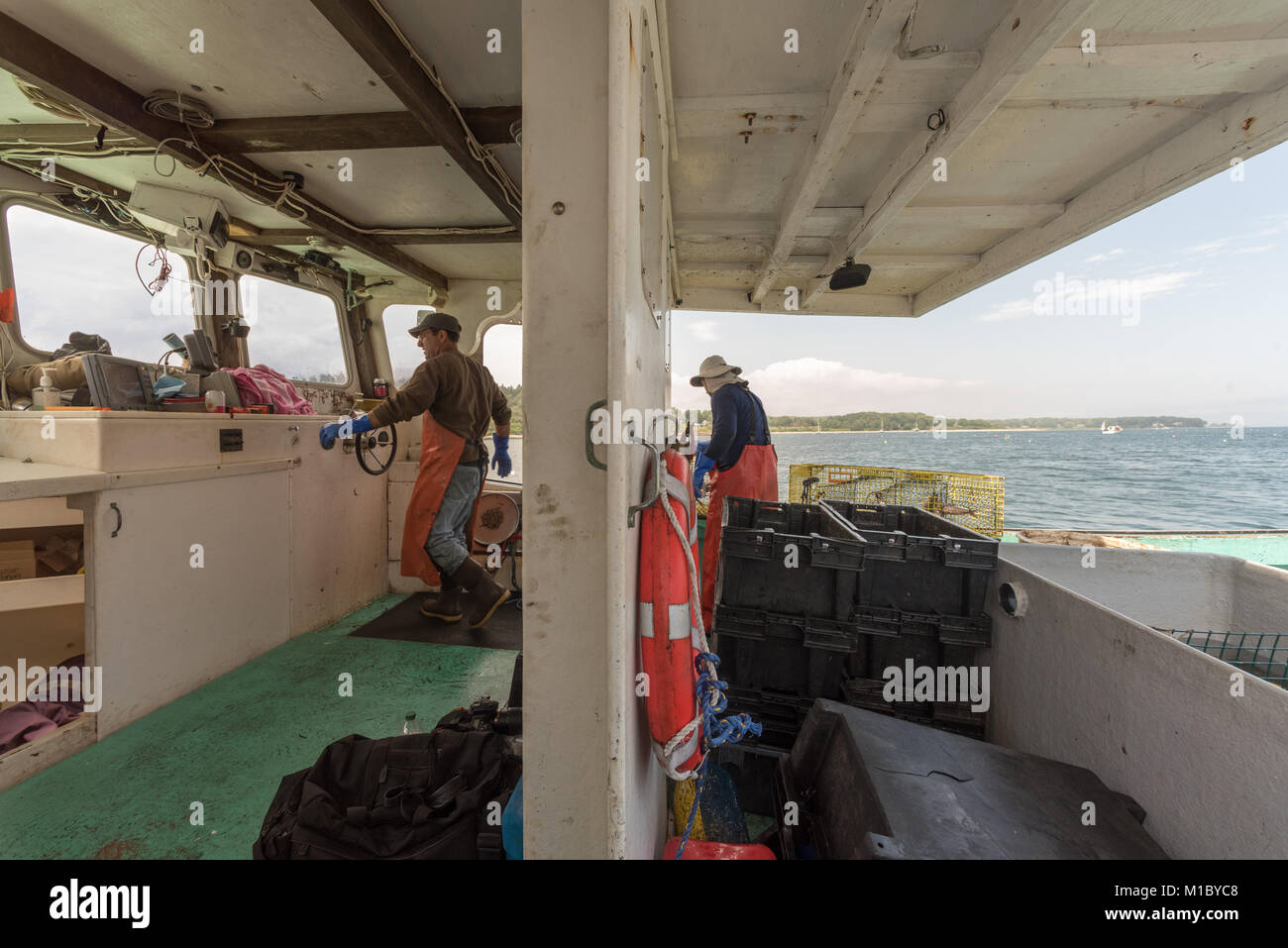 Le capitaine et sternman travaillant sur bateau de pêche du homard. Chebeague Island, Casco Bay, Maine Banque D'Images