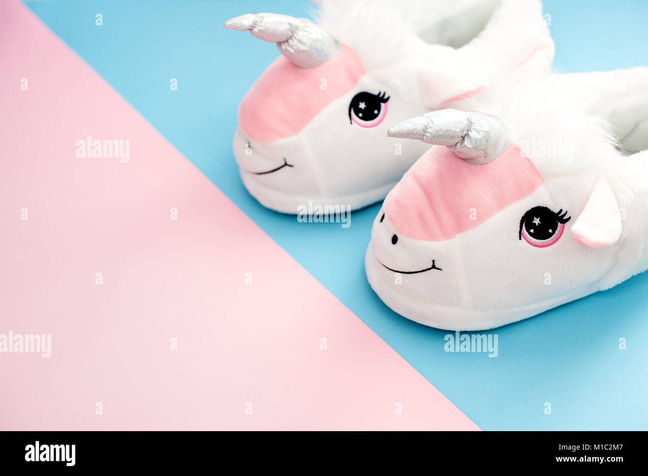 Pop art paire de chaussons moelleux unicorn blanc sur fond de couleur pastel Banque D'Images