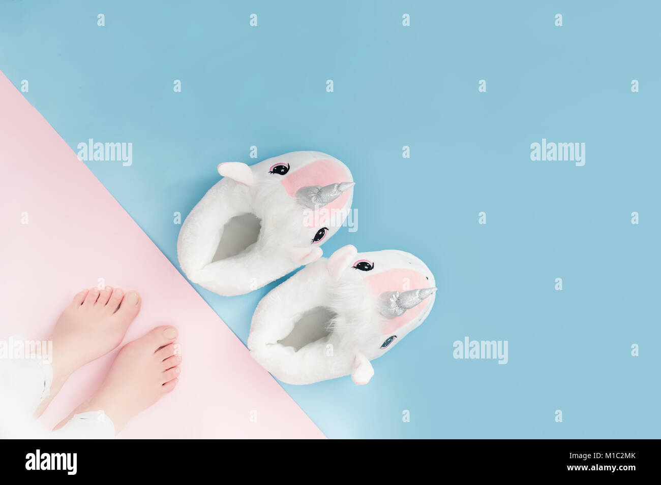 Pop art paire de chaussons moelleux unicorn blanc sur fond de couleur pastel Banque D'Images