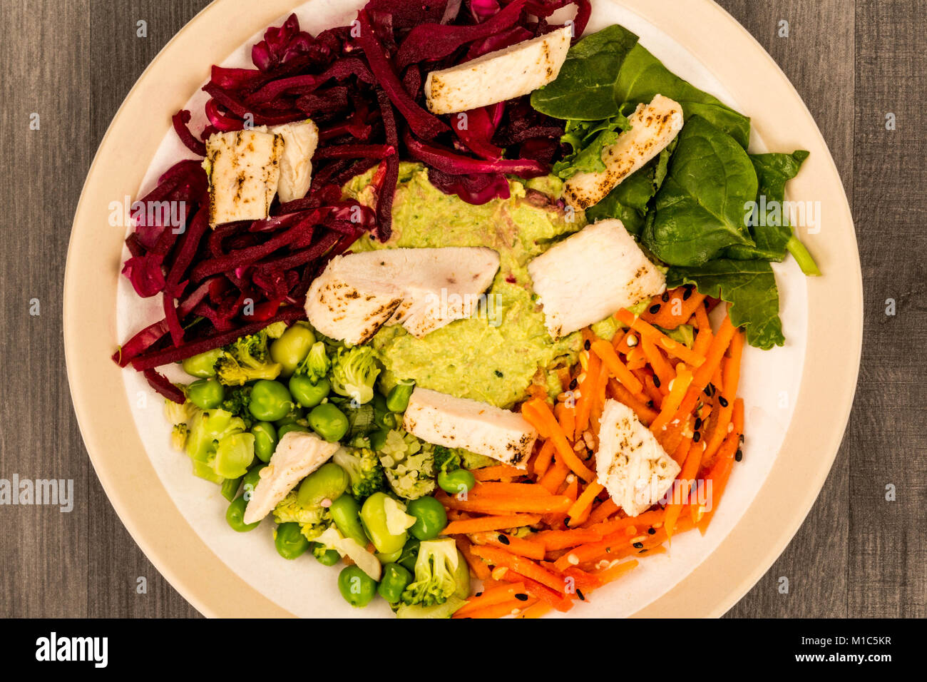 Style asiatique Salade de poulet cuits au feu avec du choux rouge Carottes Edamame Beans et l'hoummos contre un arrière-plan en bois foncé Banque D'Images