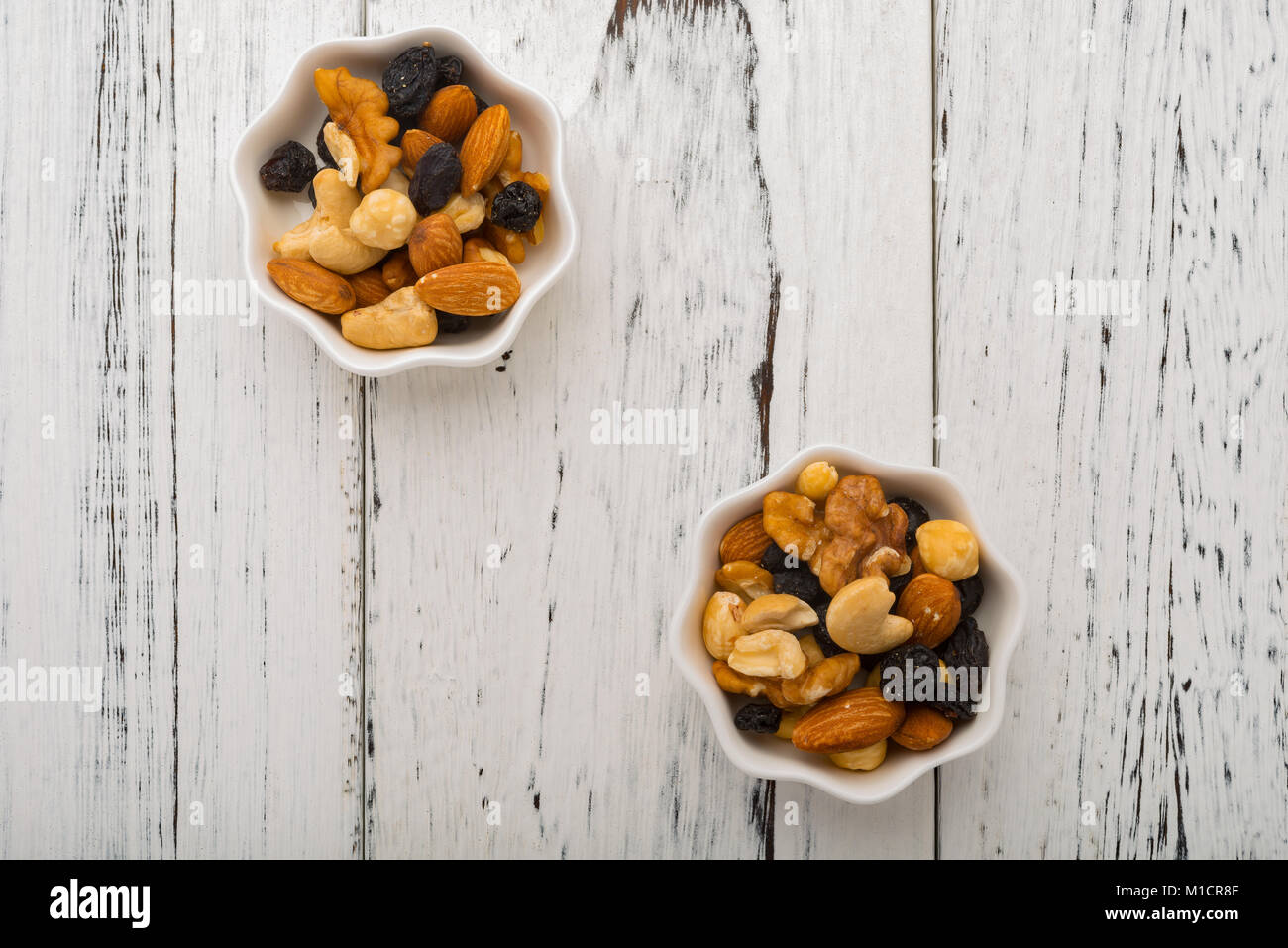 Vue de dessus les amandes et les noix de cajou et aux raisins secs et et les bleuets sur deux plats blanc Banque D'Images