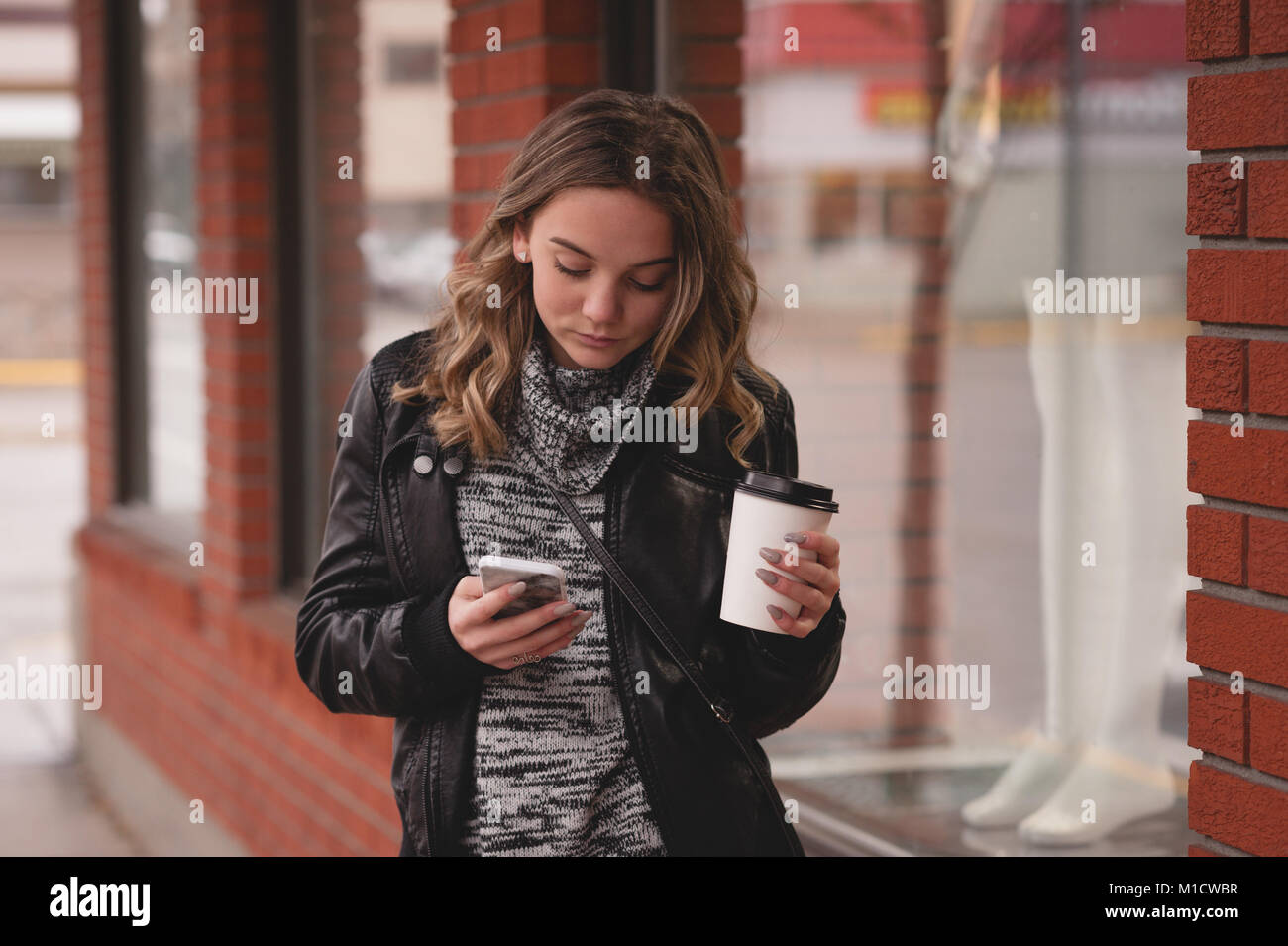 Belle fille à l'aide de mobile alors que le café Banque D'Images