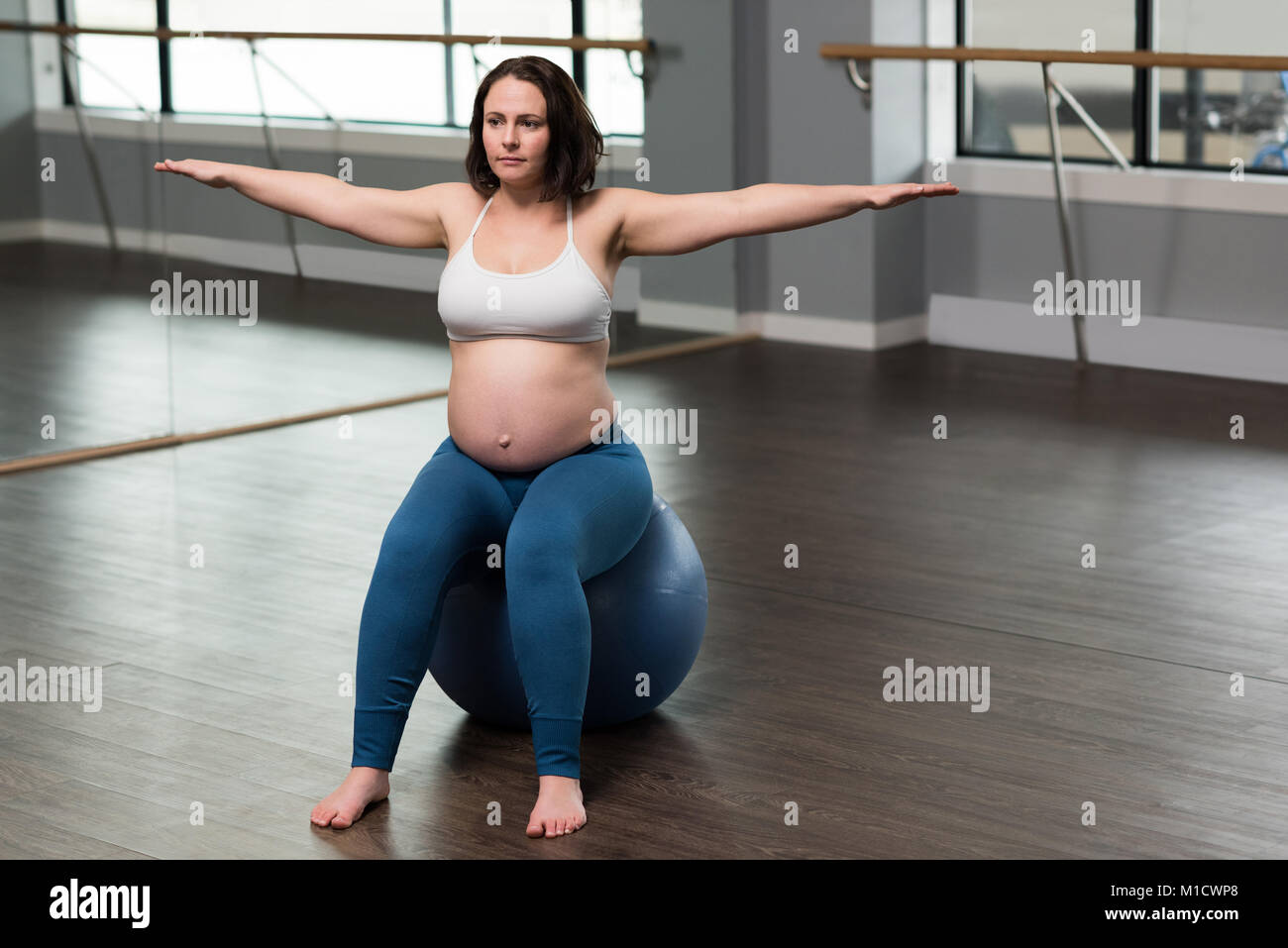 Pregnant woman exercising on exercise ball Banque D'Images