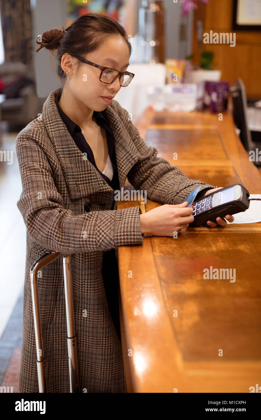 Femme balayant sa carte sur la borne de paiement automatique Banque D'Images