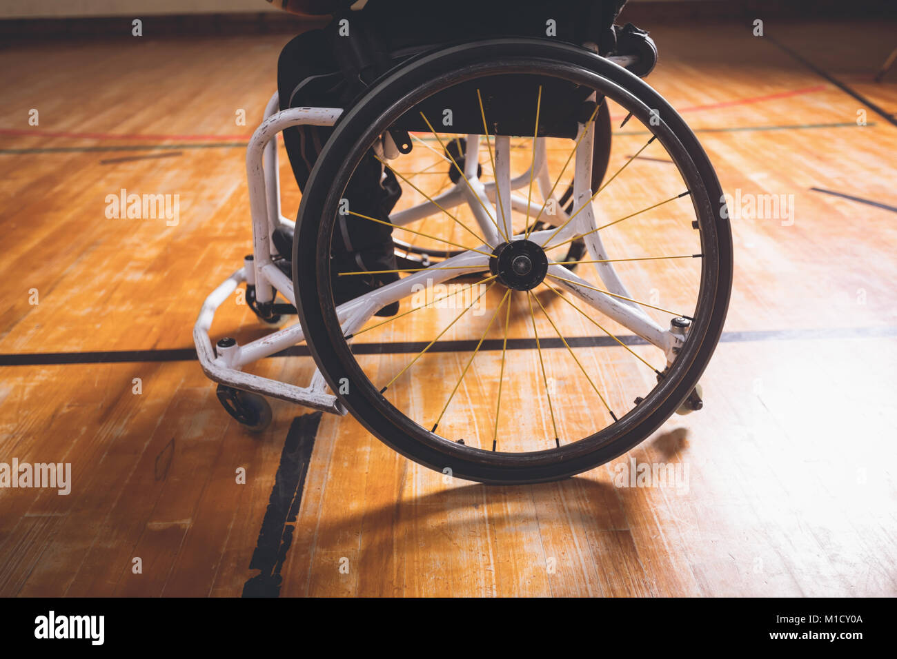 Homme handicapé en fauteuil roulant à un terrain de basket-ball Banque D'Images