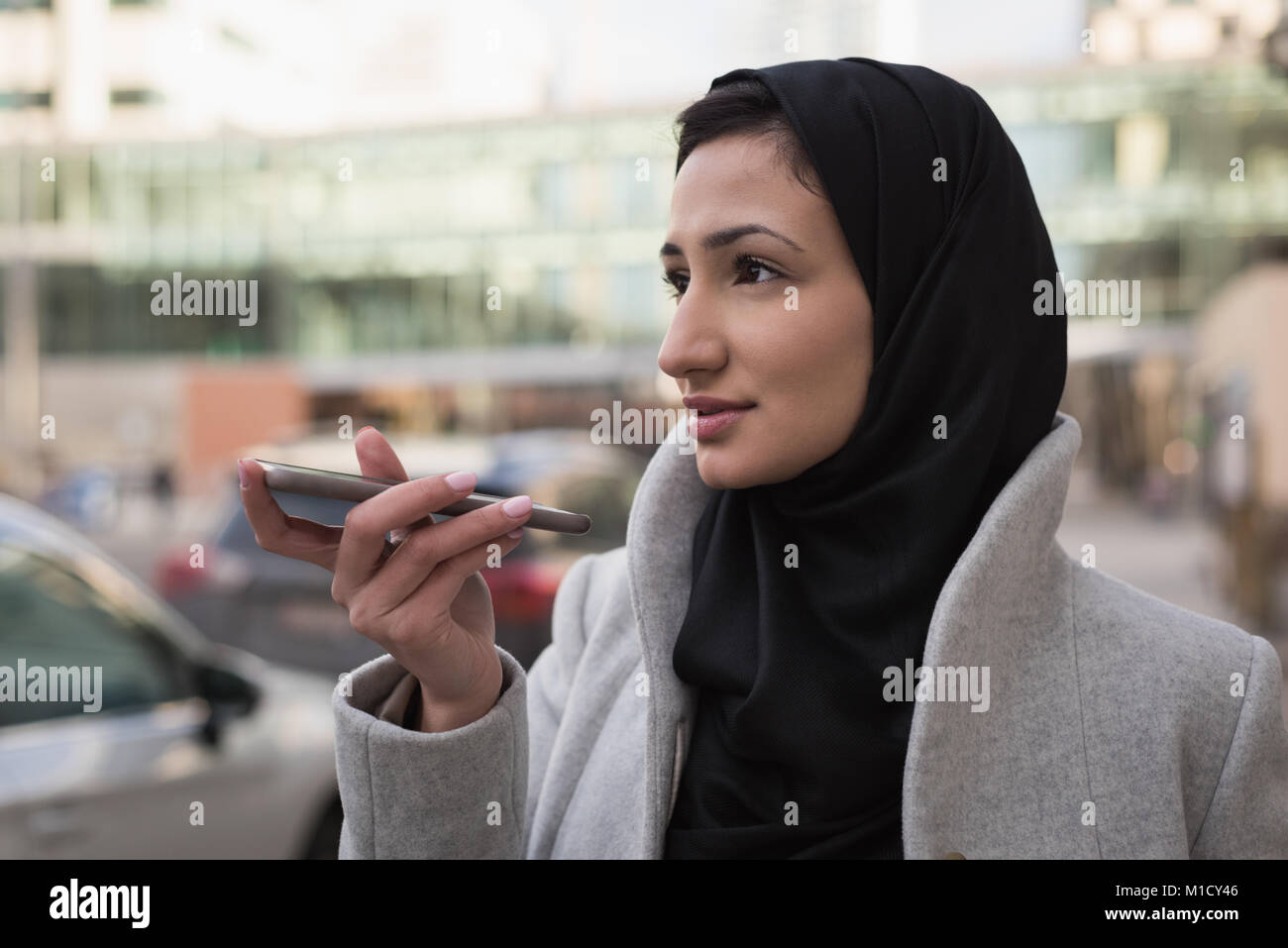 Femme en hijab talking on mobile phone Banque D'Images