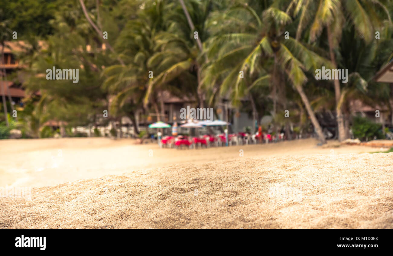 Côte plage tropicale de sable de fond sur le premier plan et arrière-plan flou palmiers sur Banque D'Images