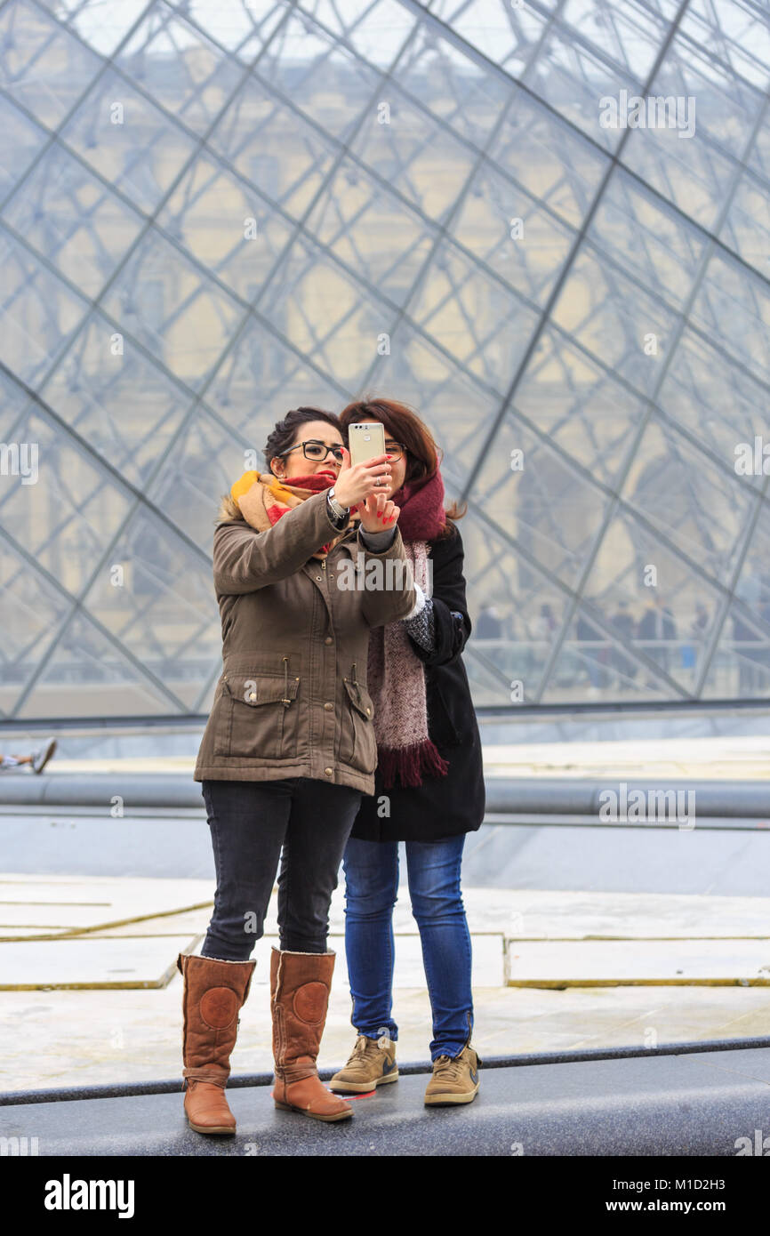 Les gens prennent vos autoportraits et photos à l'entrée de la pyramide de verre du Louvre à Paris, France Banque D'Images