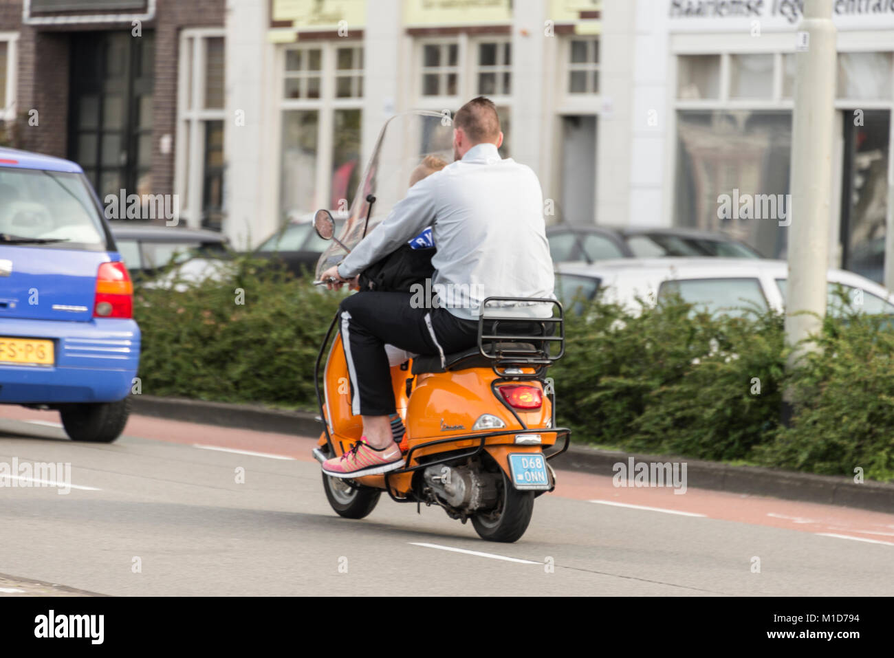 Selon la législation néerlandaise, il n'est pas une exigence pour toute  personne en raison d'une moto ou un scooter 30cc à moins de porter un  casque de protection. Un père sur son