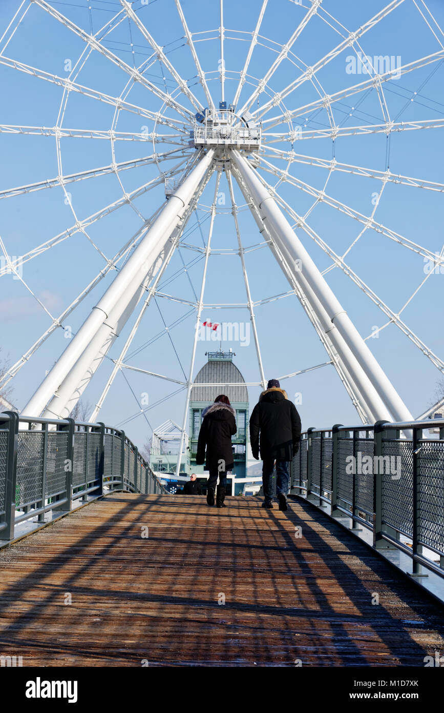 Les personnes qui traversent un pont dans le Vieux Port (Vieux Port) Salon de Montréal avec la grande roue La Grande Roue derrière Banque D'Images