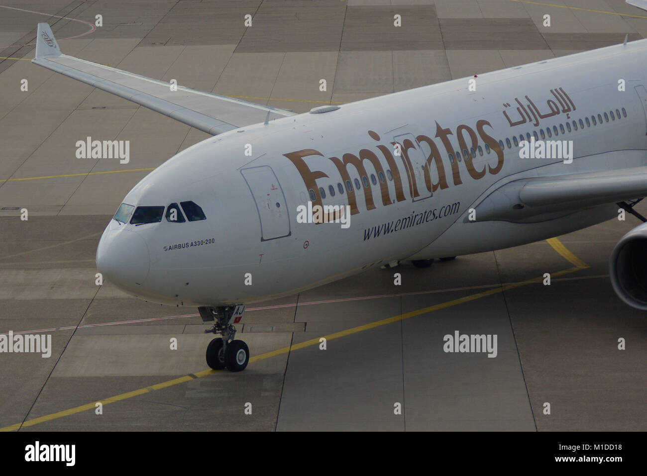 Airbus A330-200 d'Emirates sur le chemin de pont d'embarquement des passagers Banque D'Images