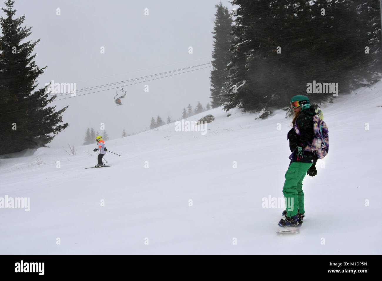 Aleko, Bulgarie - le 21 janvier 2018 : young woman snowboarder sur la pente en hiver blizzard dans la montagne Vitosha. Téléski à peine visibles à distance Banque D'Images