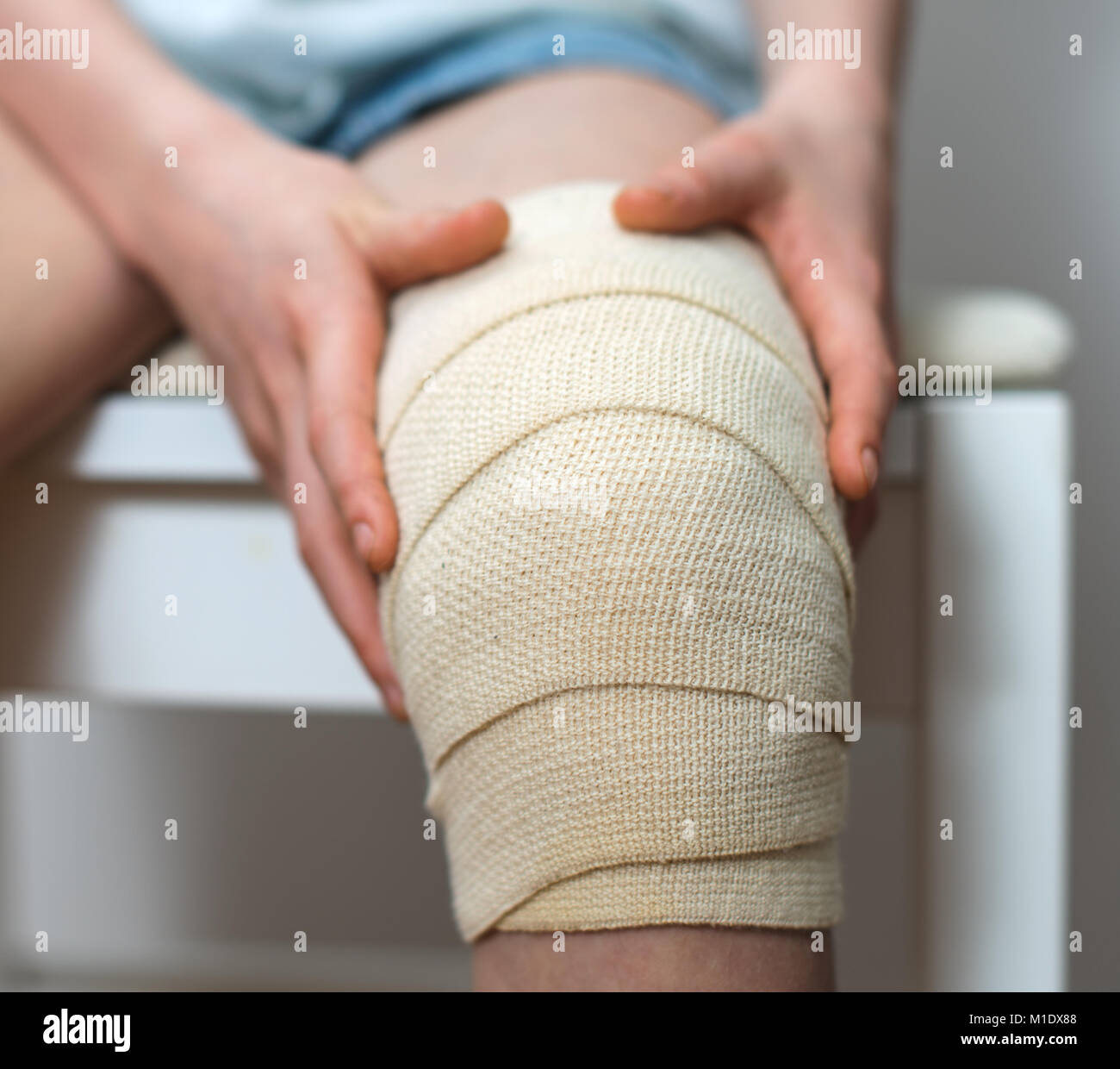 Genou enfant avec bandage élastique sur elle. Banque D'Images