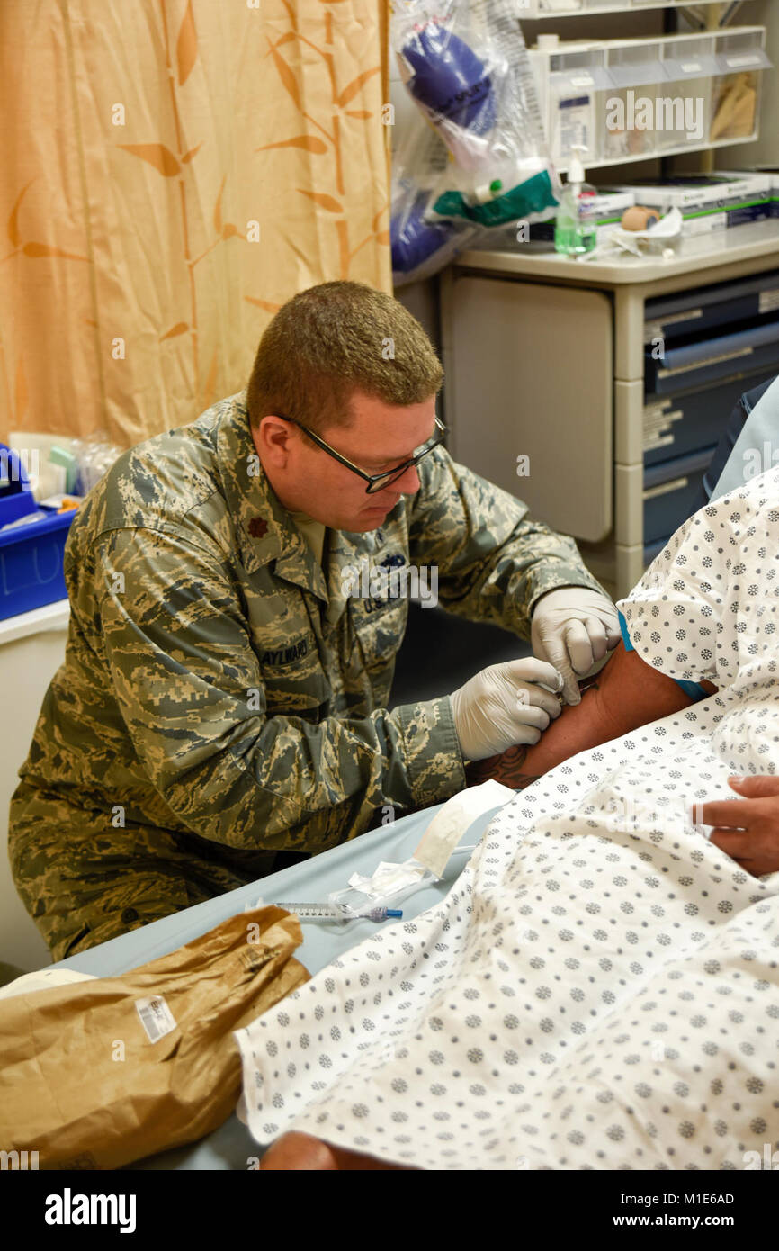 Le Major Justin Aylward, 114e Groupe médical infirmière clinique, un nserts IV sur un patient à la Tripler Army Medical Center salle d'urgence le 17 janvier 2018, Honolulu, HI. Environ 15 aviateurs du 114e Groupe médical a travaillé à CGAT et Schoffield Barracks clinique de santé.(U.S. Air National Guard Banque D'Images