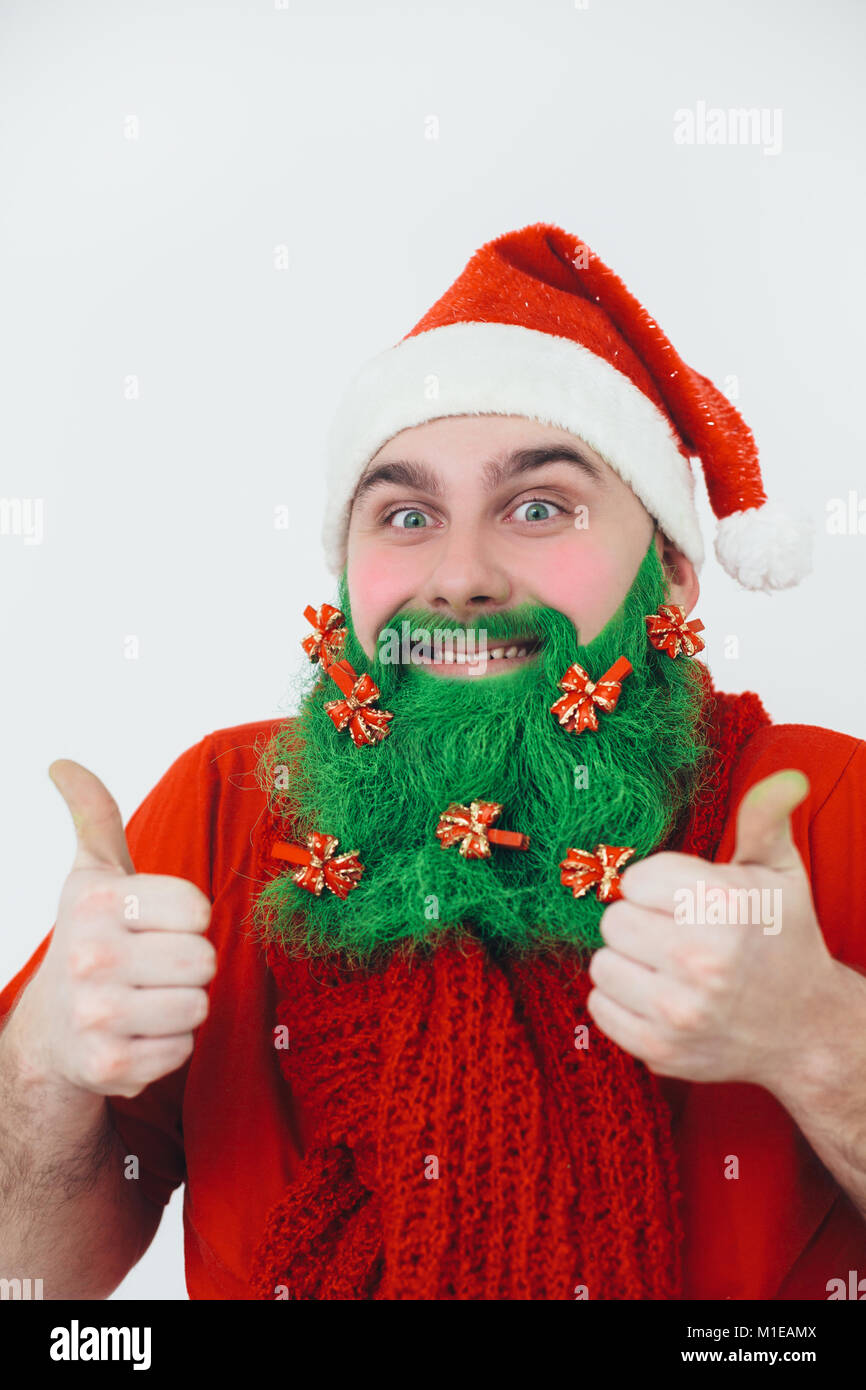 Le Père Noël en rouge vêtements avec barbe rouge vert décoré d'arcs montre pouce-up Connexion et sourire Banque D'Images