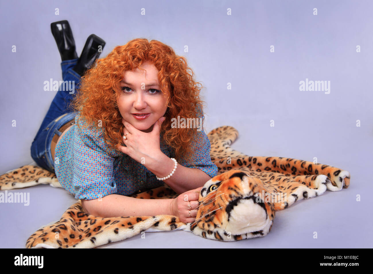Portrait de la belle rousse se trouvant dans le studio sur la peau de léopard Banque D'Images