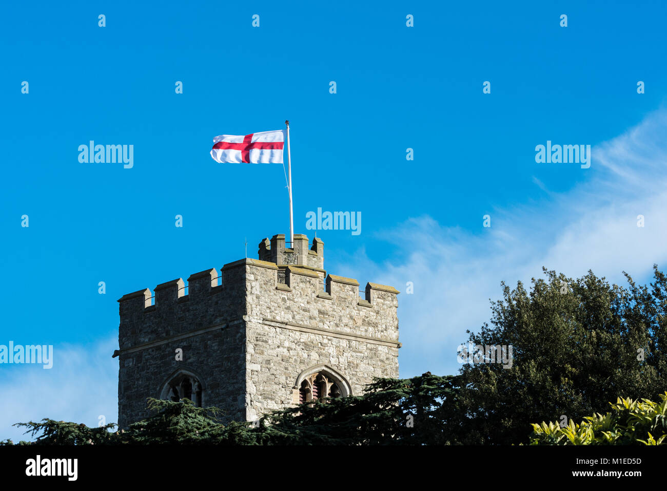Dans un parfait ciel bleu, le drapeau de St George vole sur la tour de l'église St Clements, Leigh on Sea Banque D'Images