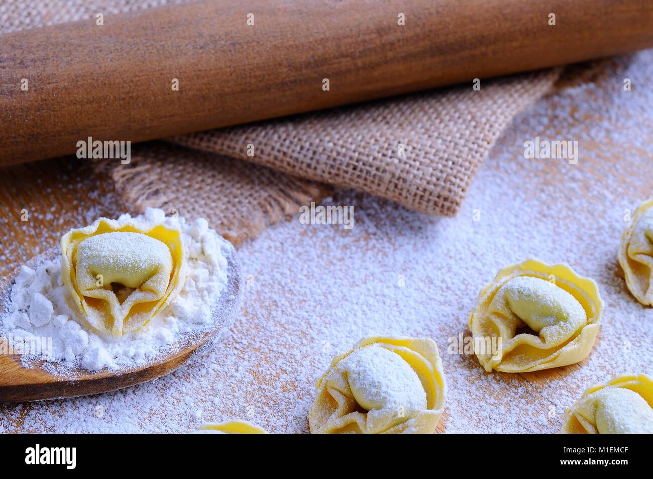 La préparation des tortellini sur table en bois dans la cuisine. Banque D'Images
