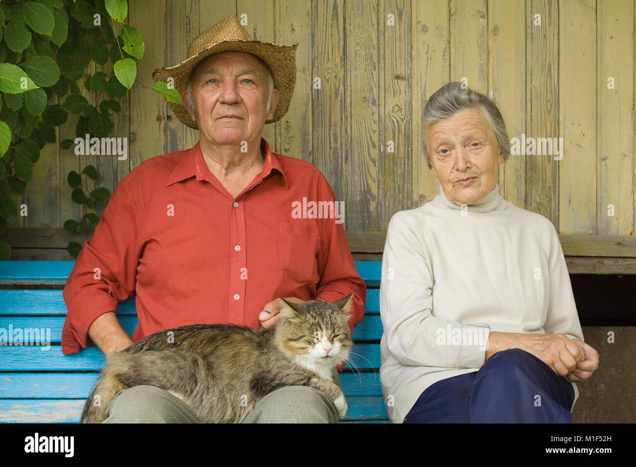 Vieux couple avec cat s'asseoir en plein air Banque D'Images