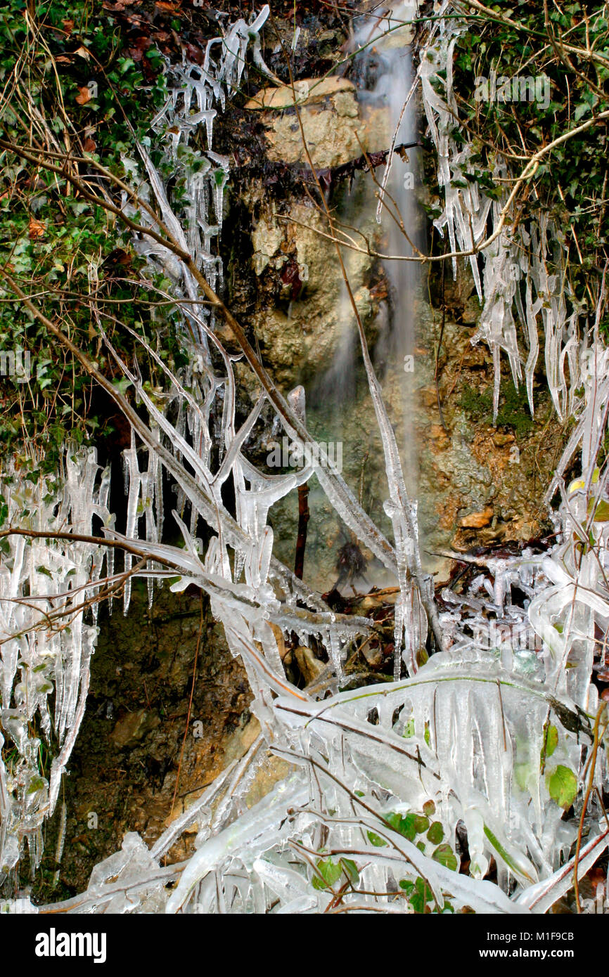 Les glaçons autour d'une petite roche stream par temps froid Banque D'Images