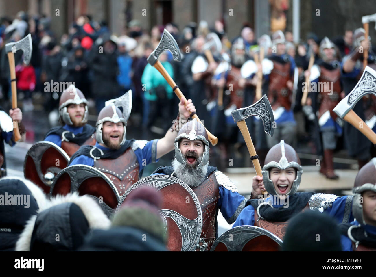 Les membres de l'équipe de Jarl vêtus de costumes Viking marche dans les rues de Lerwick sur les îles Shetland pendant le Festival Up Helly Aa Viking. Banque D'Images