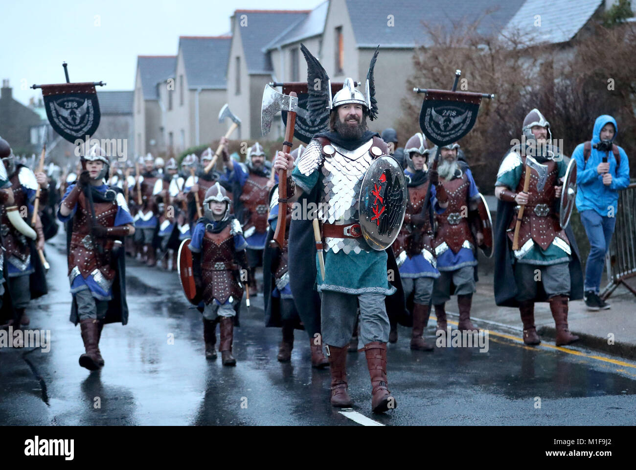 Les membres de l'équipe de Jarl vêtus de costumes Viking marche dans les rues de Lerwick sur les îles Shetland pendant le Festival Up Helly Aa Viking. Banque D'Images
