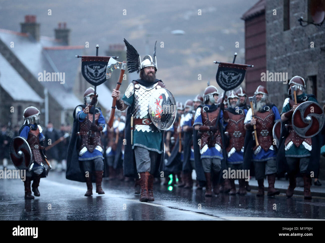 Les membres de l'équipe de Jarl vêtus de costumes Viking marche dans les rues de Lerwick sur les îles Shetland pendant le Festival Up Helly Aa Viking. Banque D'Images