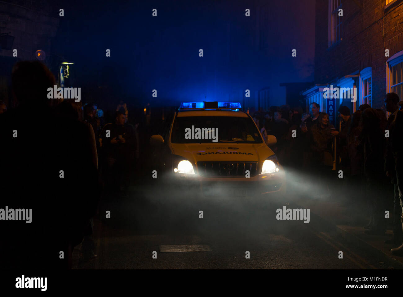 Une ambulance fait son chemin à travers les rues bondées de nuit clignoter ses feux bleus. Bonfire Night 2017 seigle, uk Banque D'Images