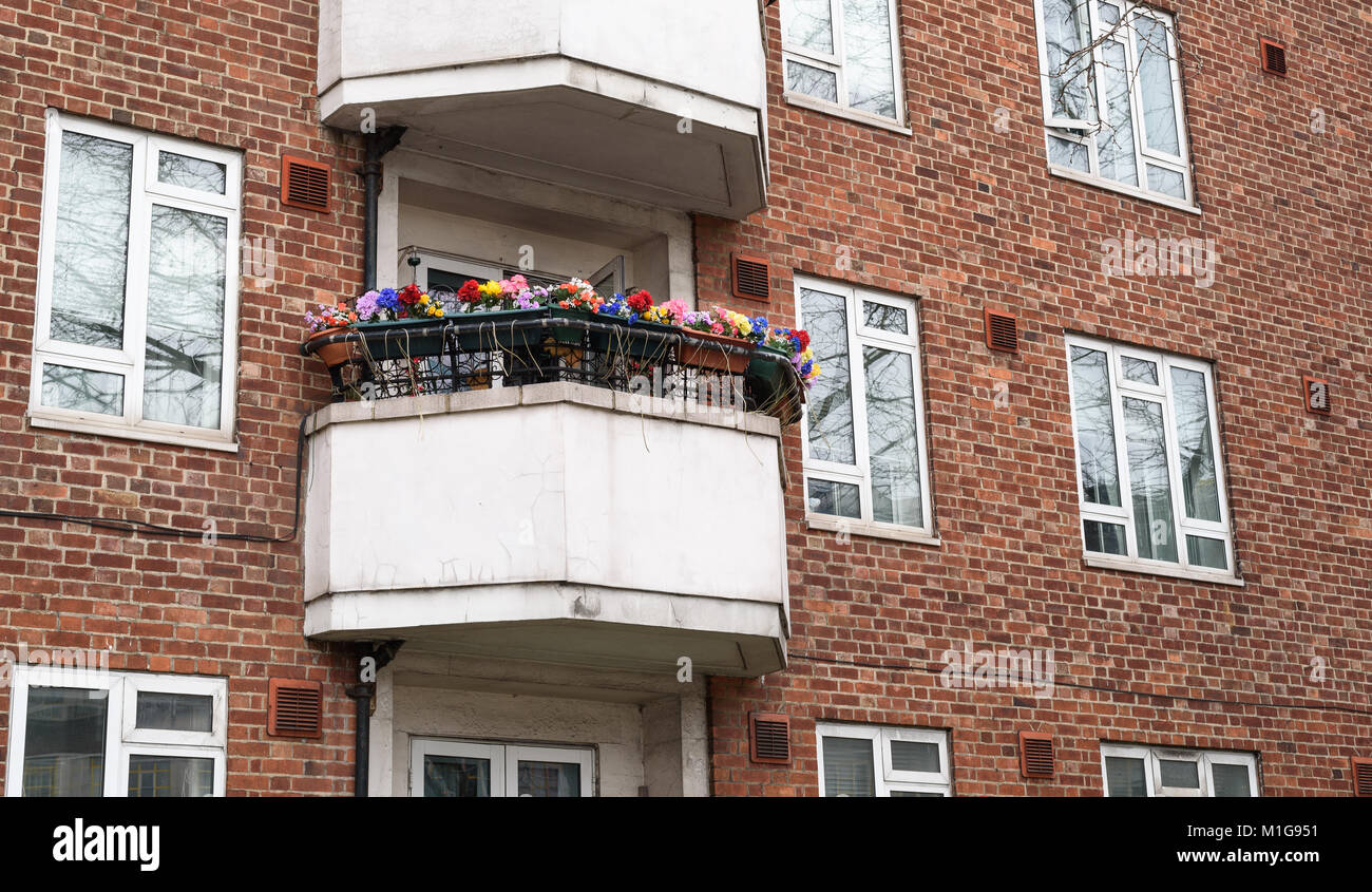 Faux en plastique fleurs décorant un haut lieu urbain balcon. Banque D'Images