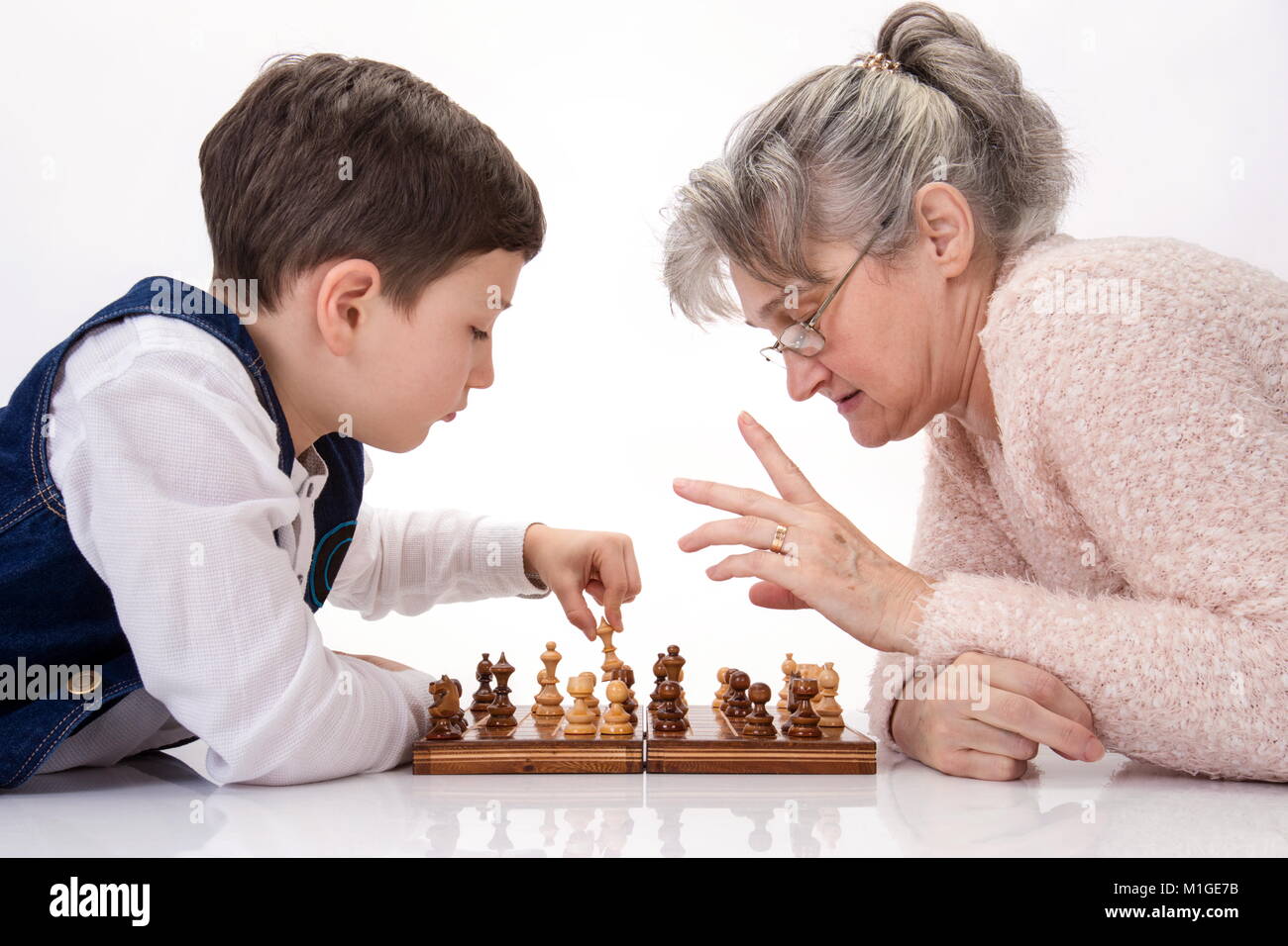 Grand-mère et son neveu jouant aux échecs face à face Banque D'Images