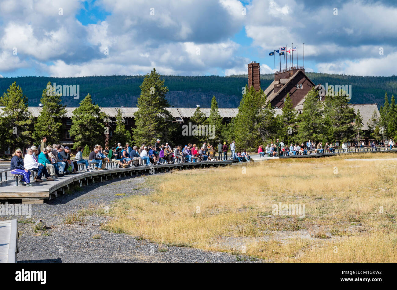 Les touristes assis sur des bancs en attente d'Old Faithful Geyser. Le Parc National de Yellowstone, Wyoming, USA Banque D'Images