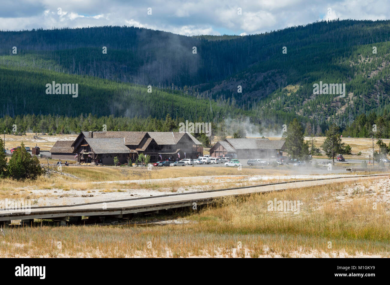 La vapeur s'élève des zones thermiques en face du centre d'Old Faithful. Le Parc National de Yellowstone, Wyoming, USA Banque D'Images