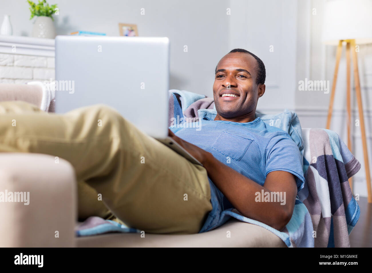 Homme heureux positive allongé sur le canapé Banque D'Images