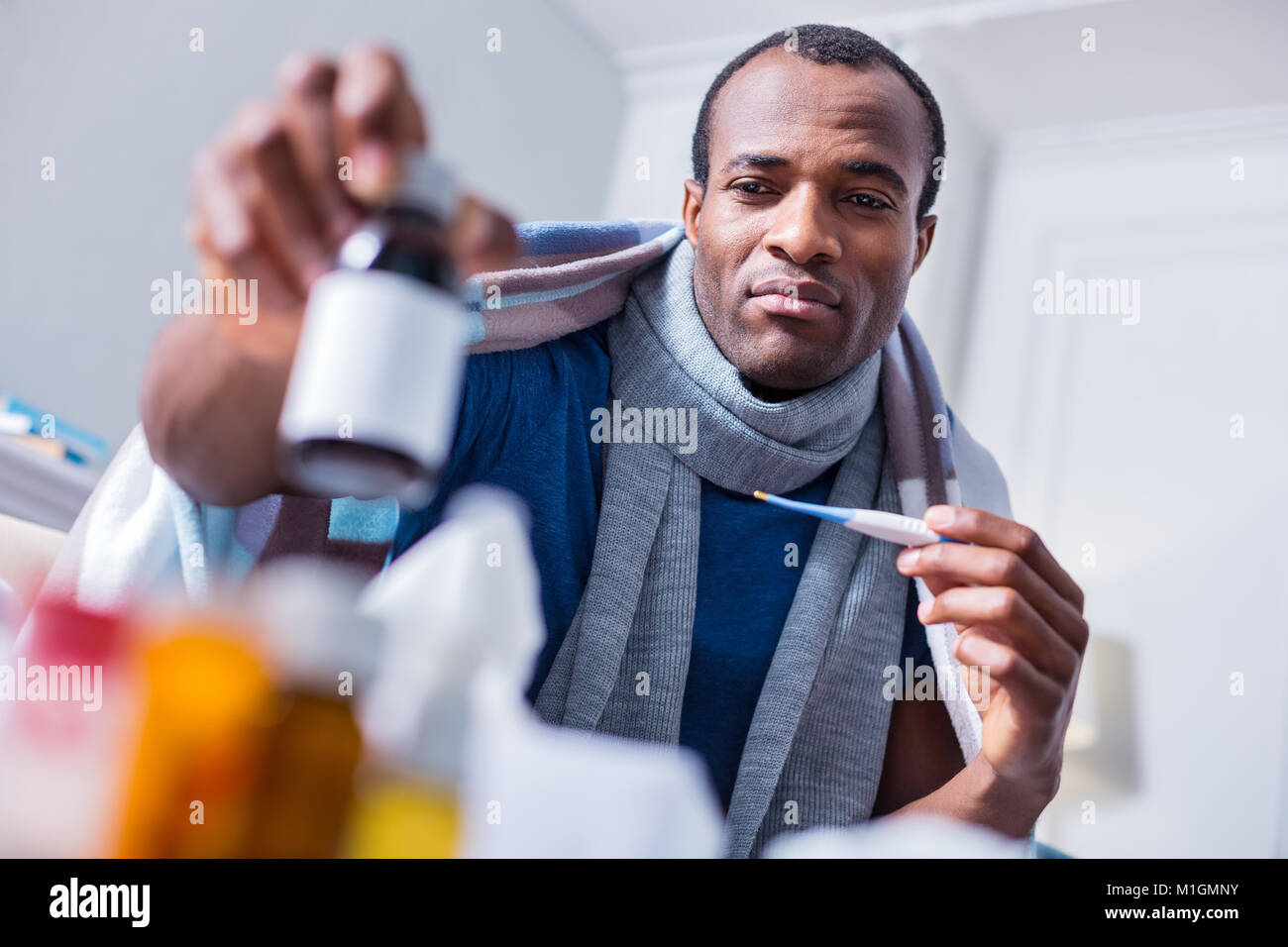 Triste homme adulte à la recherche de la bouteille avec la médecine Banque D'Images